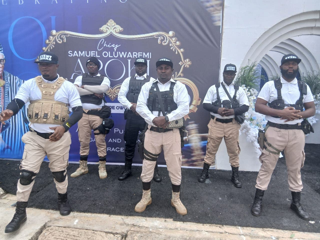 Six Event Squad bouncers on duty in front of the banner at an eightieth birthday celebration