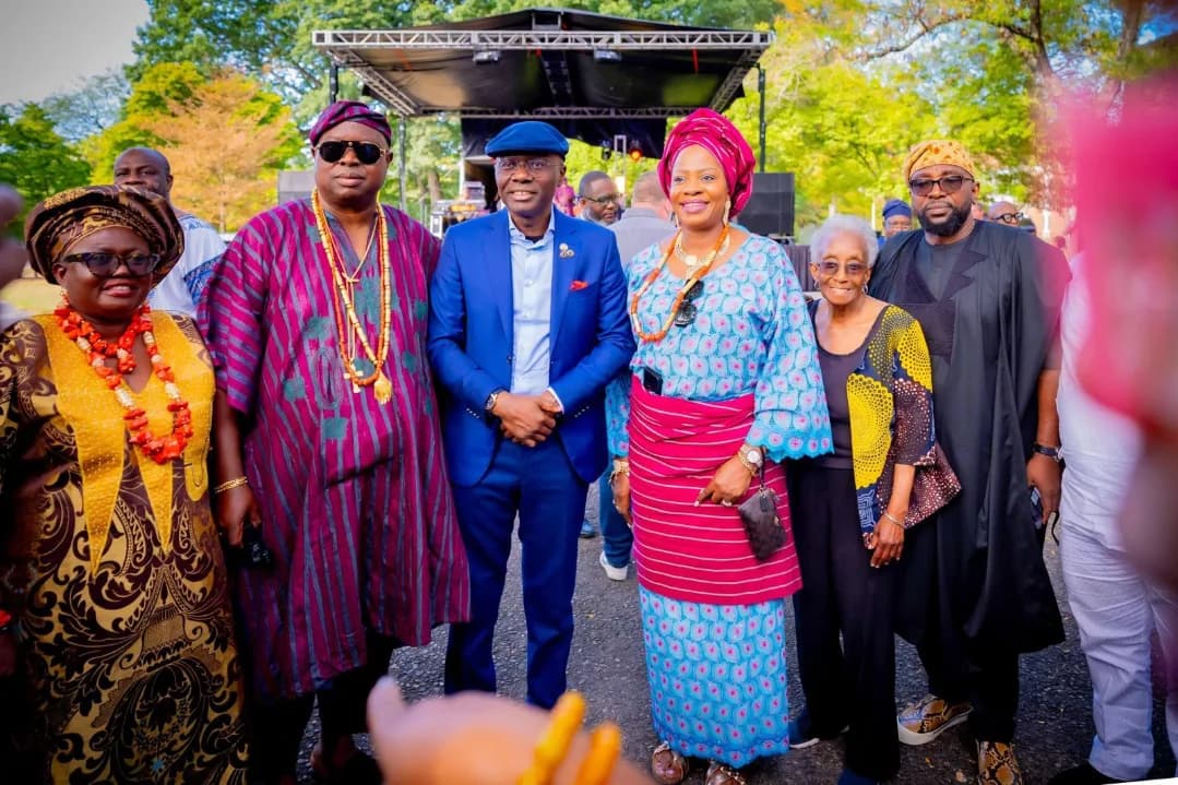 Guests of honour in full Nigerian dress photographed together in front of the main stage at an outdoor reception
